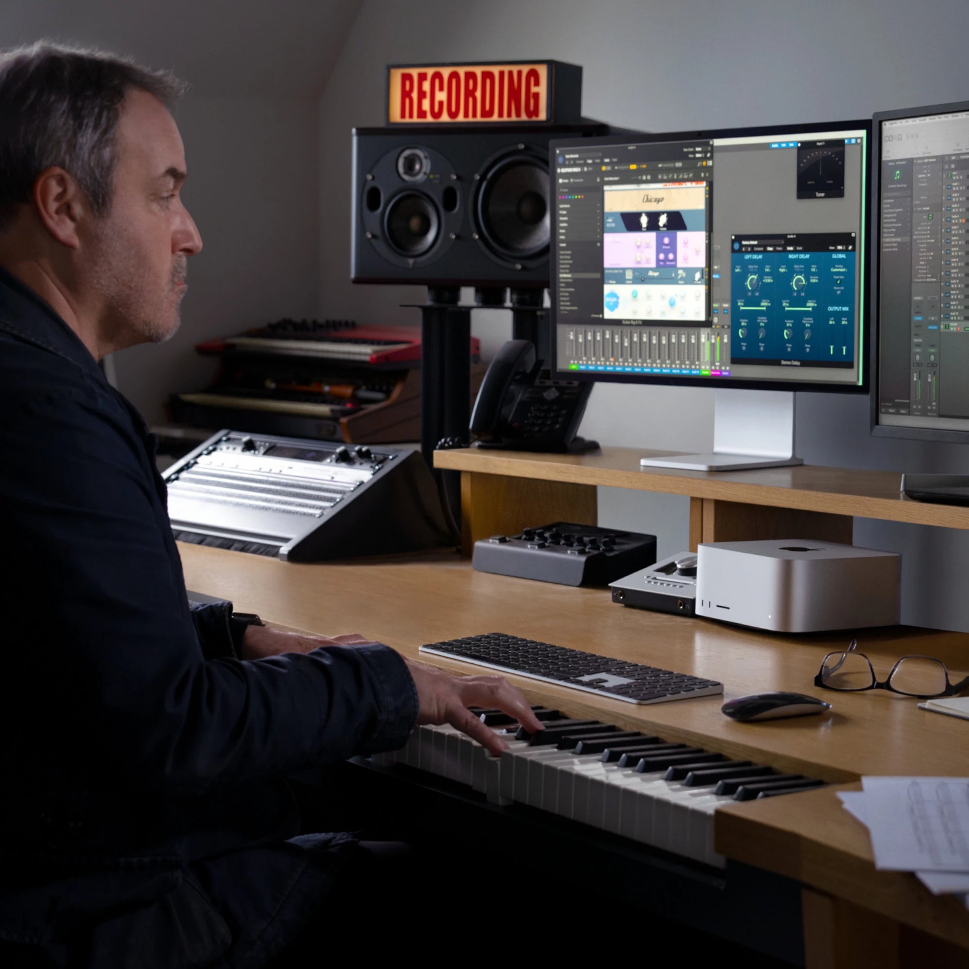 Music producer using Apple Mac Studio M2 Ultra 2025 with dual monitors and MIDI keyboard